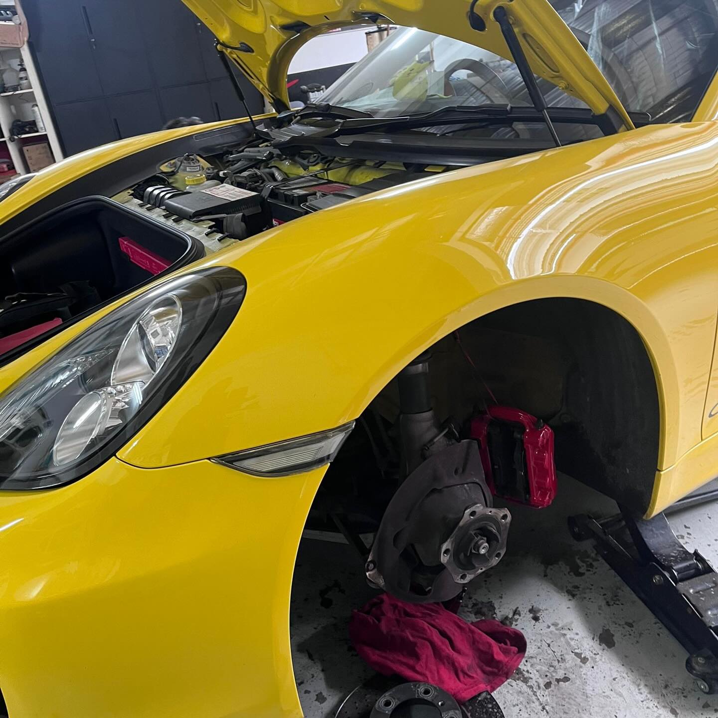 Porsche Cayman S with a wheel removed for brake maintenance