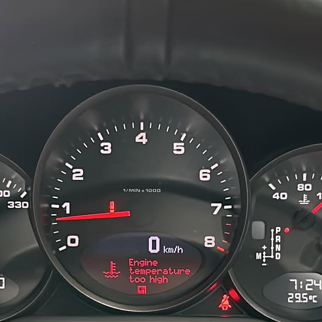 Porsche instrument cluster showing a cooling-system warning