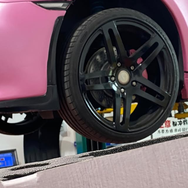 Porsche Cayman wheel and workshop view during a speaker upgrade